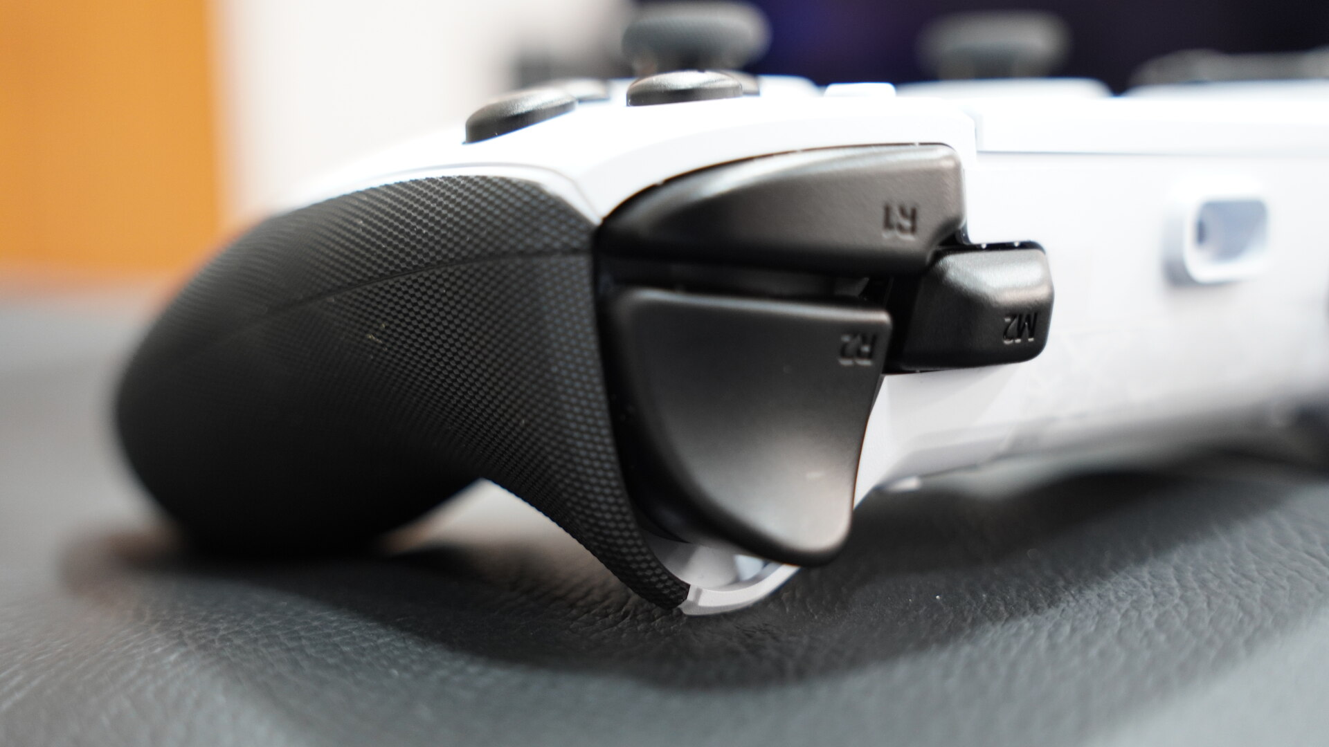 Close-up lateral do comando Razer Raiju V3 Pro branco mostrando gatilhos pretos e pega com textura antiderrapante.